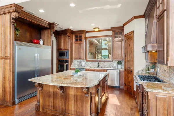 a kitchen with stainless steel appliances granite countertop a sink a stove and refrigerator