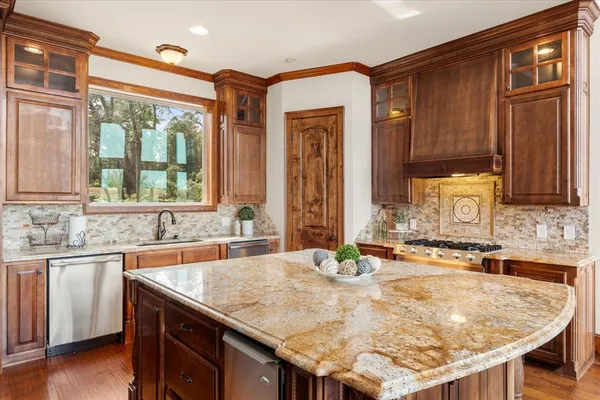 a kitchen with granite countertop a sink and a refrigerator