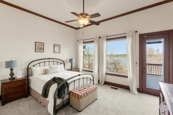 a bedroom with a large bed and a chandelier fan