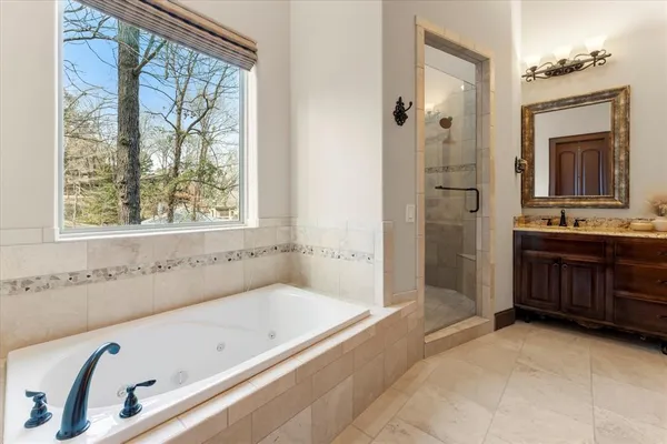 a bathroom with a tub sink and mirror
