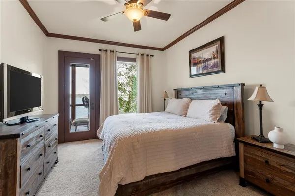 a bedroom with a bed and a flat tv screen on dresser
