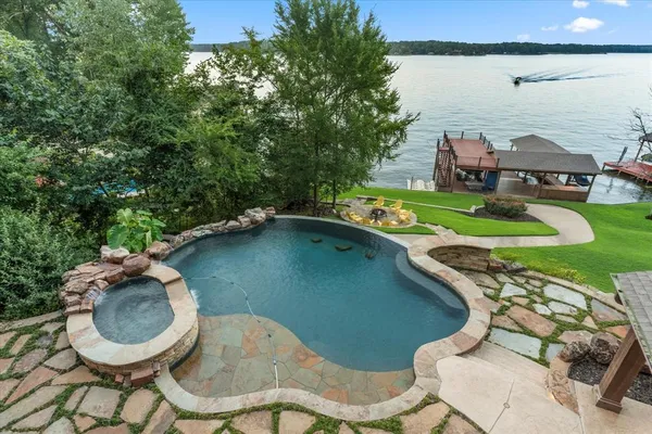 a view of a swimming pool with lawn chairs and a yard
