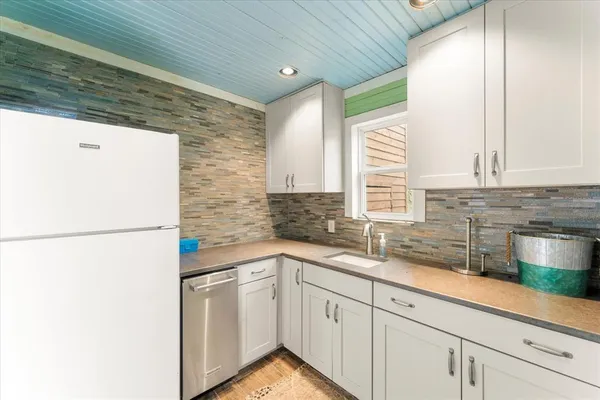 a kitchen with a sink a refrigerator and cabinets