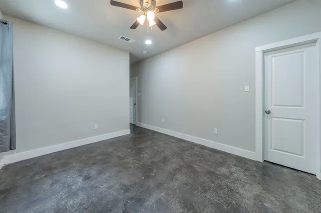 an empty room with a chandelier fan