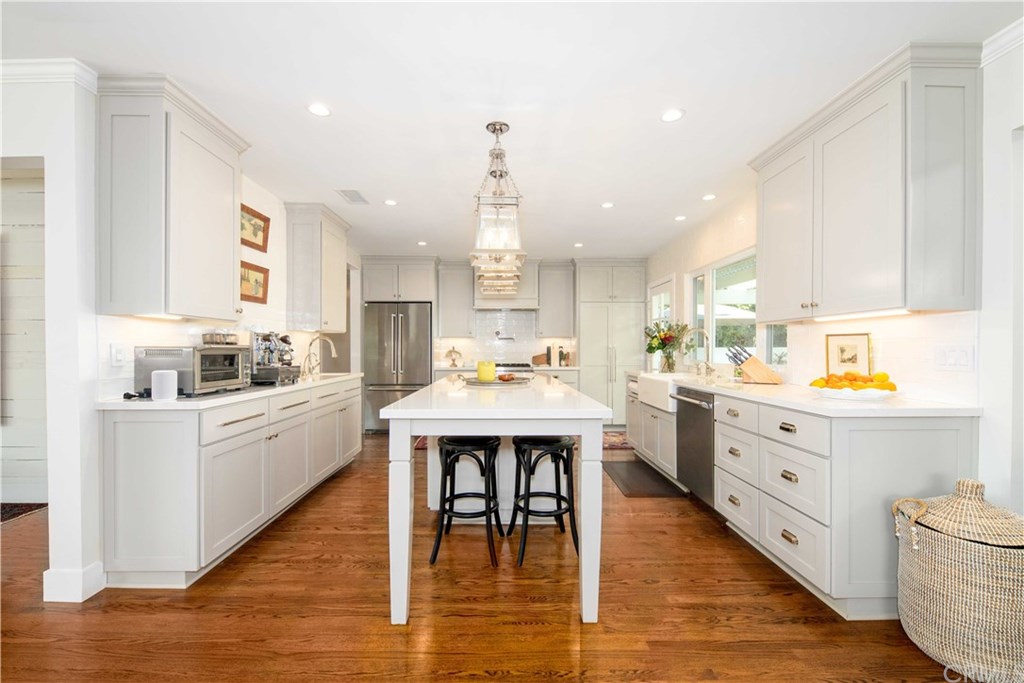 a kitchen with a wooden floor and white cabinets