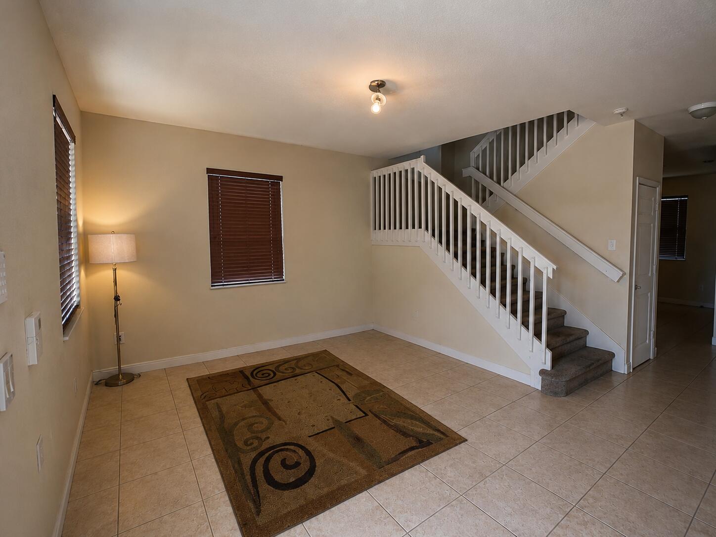 10463 Southwest 228th Terrace Miami, FL 33190 - Photo 3 of 8 a view of a livingroom with a flesh screen tv and stairs