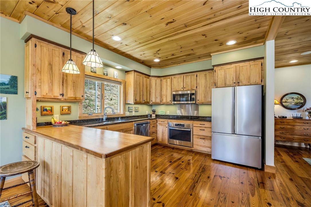 1976 Hartzog Ford Road West Jefferson, NC 28694 - Photo 26 of 50 a kitchen with granite countertop wooden floors and stainless steel appliances