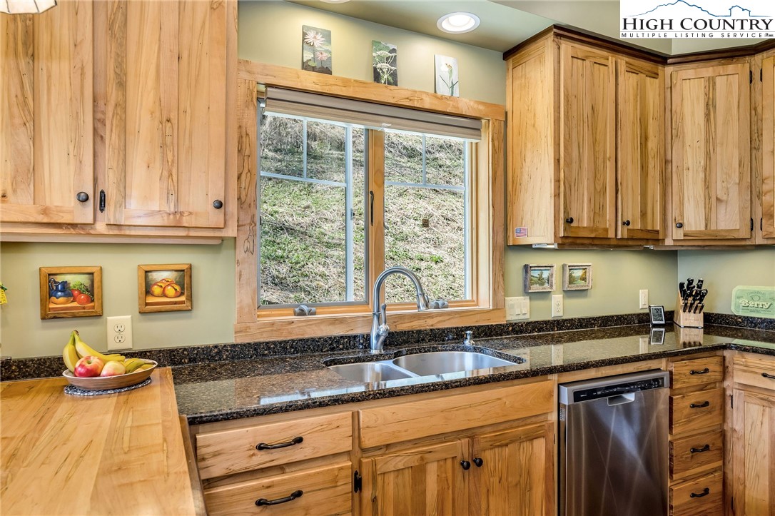 1976 Hartzog Ford Road West Jefferson, NC 28694 - Photo 27 of 50 a kitchen with stainless steel appliances granite countertop a sink a stove and cabinets