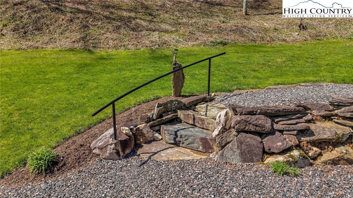 1976 Hartzog Ford Road West Jefferson, NC 28694 - Photo 9 of 50 a view of a backyard with lawn chairs floor to ceiling window and tree