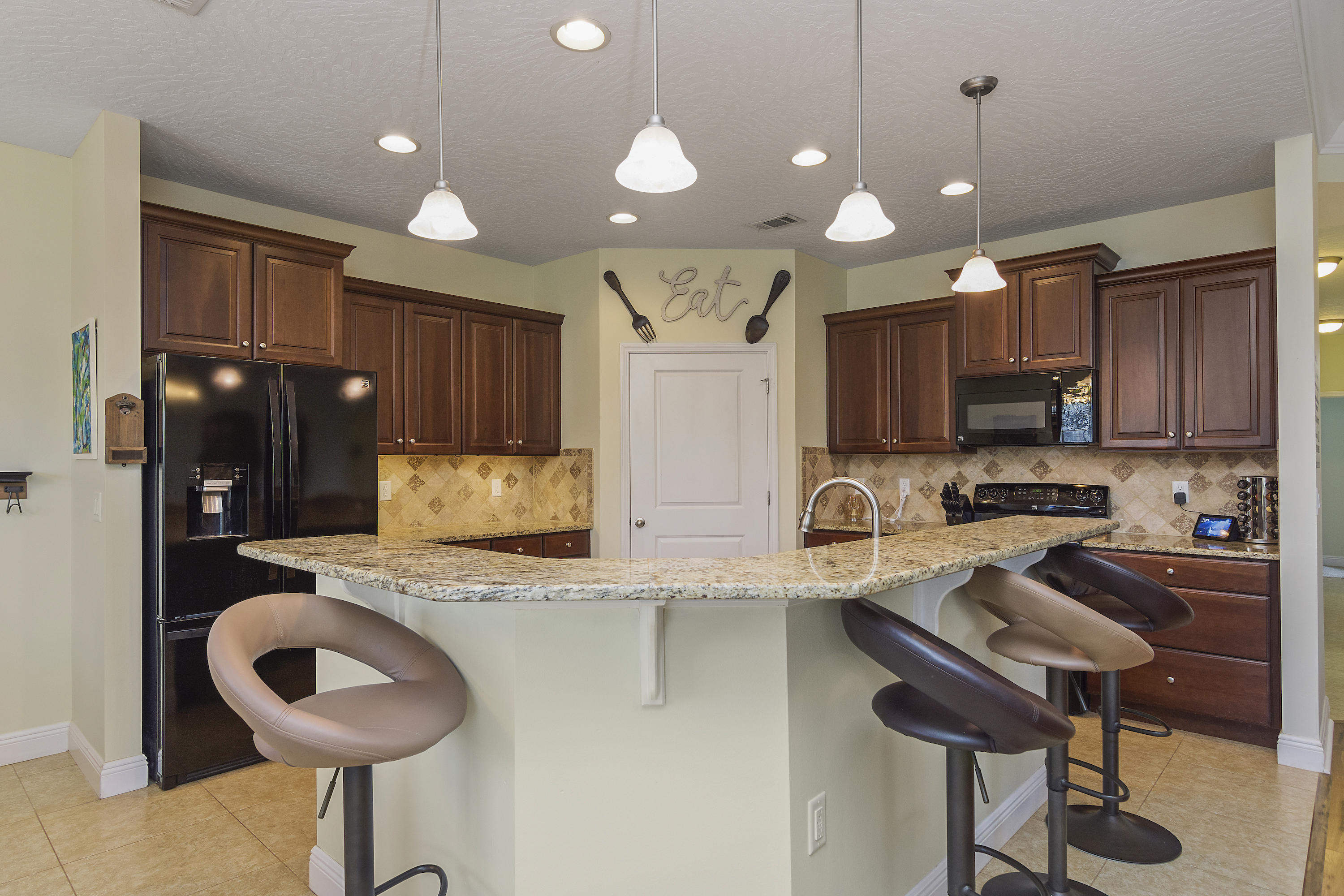 4605 Hermosa Road Crestview, FL 32539 - Photo 18 of 46 a kitchen with sink refrigerator and cabinets