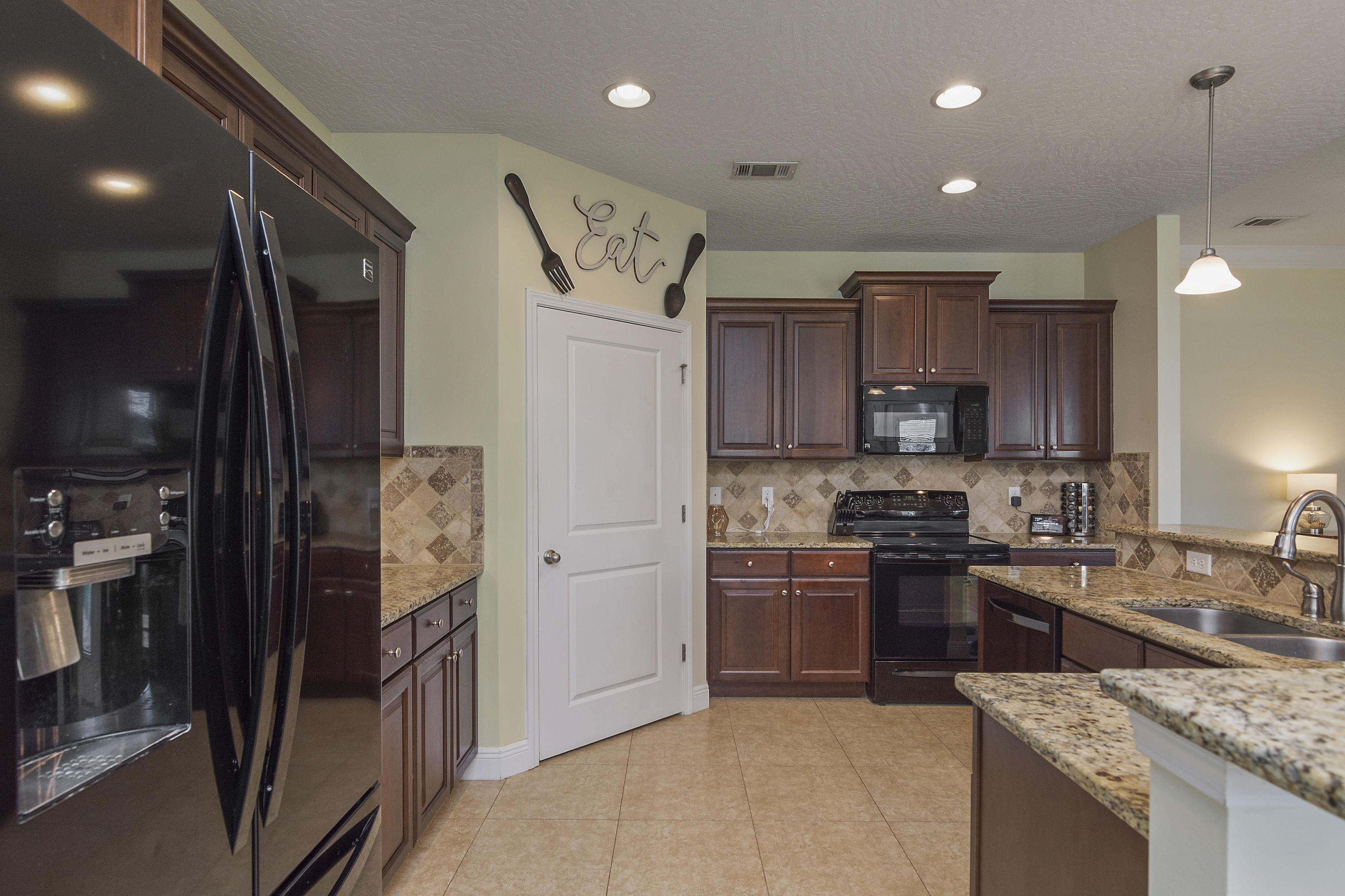 4605 Hermosa Road Crestview, FL 32539 - Photo 19 of 46 a kitchen with stainless steel appliances granite countertop a sink stove and refrigerator