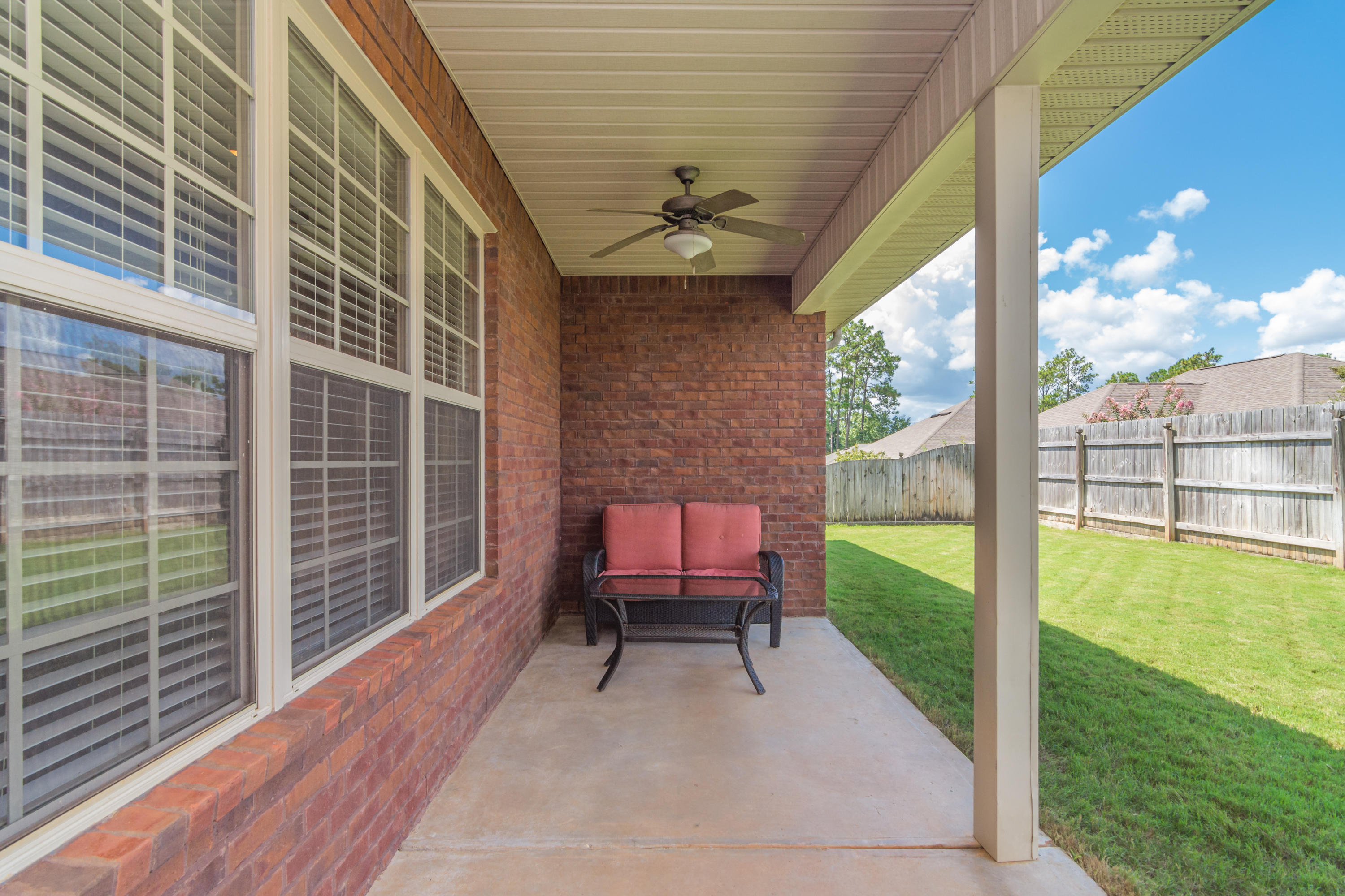 4605 Hermosa Road Crestview, FL 32539 - Photo 6 of 46 a balcony with table and chairs and wooden floor