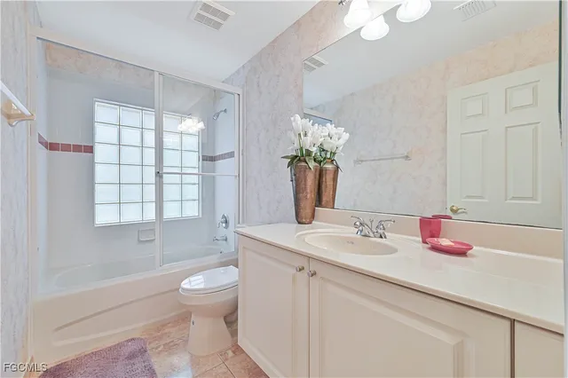 a bathroom with a granite countertop sink a toilet and shower
