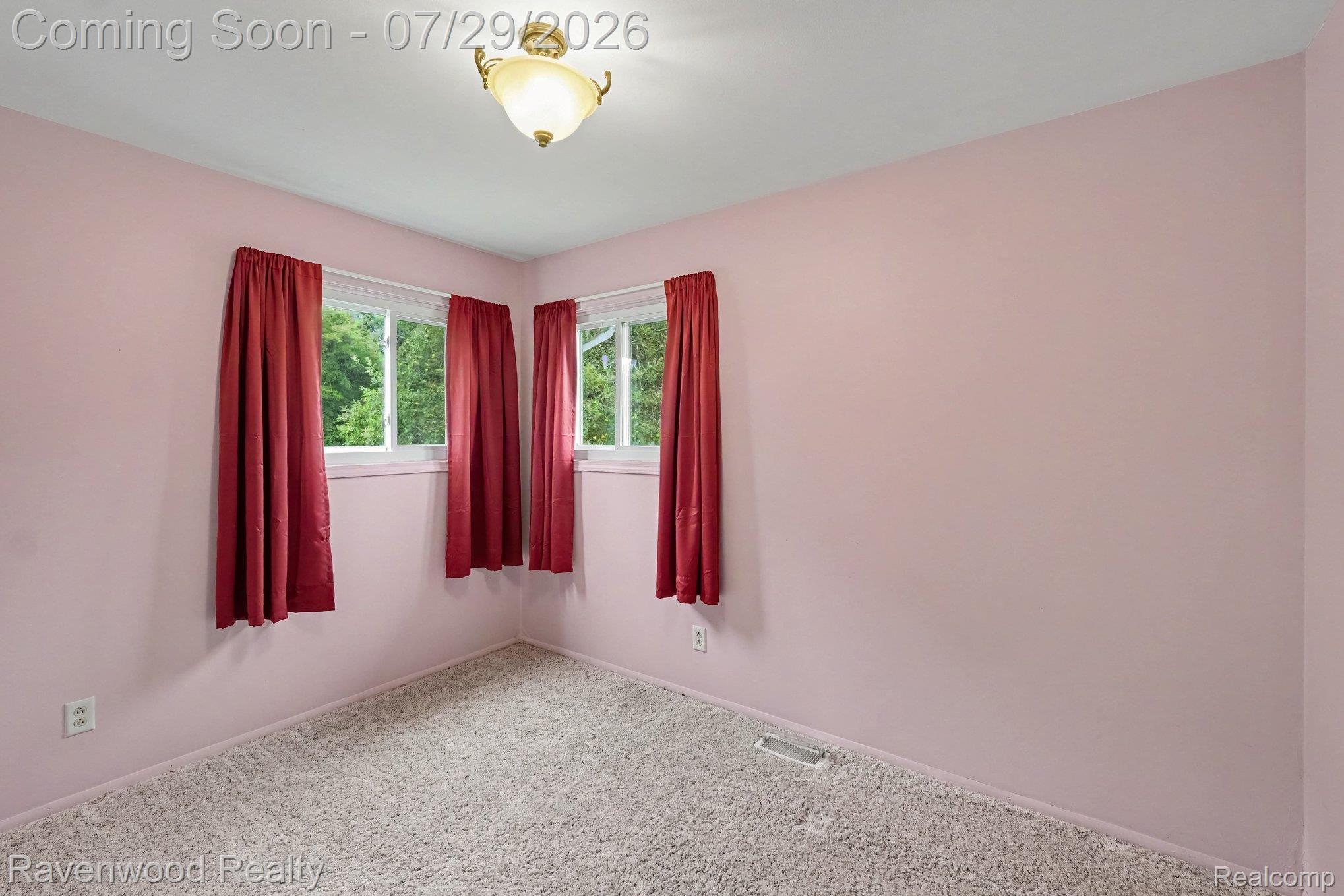 6317 East Coldwater Road Flint, MI 48506 - Photo 9 of 29 Carpeted room with three windows, a ceiling-mounted light fixture, and light pink walls