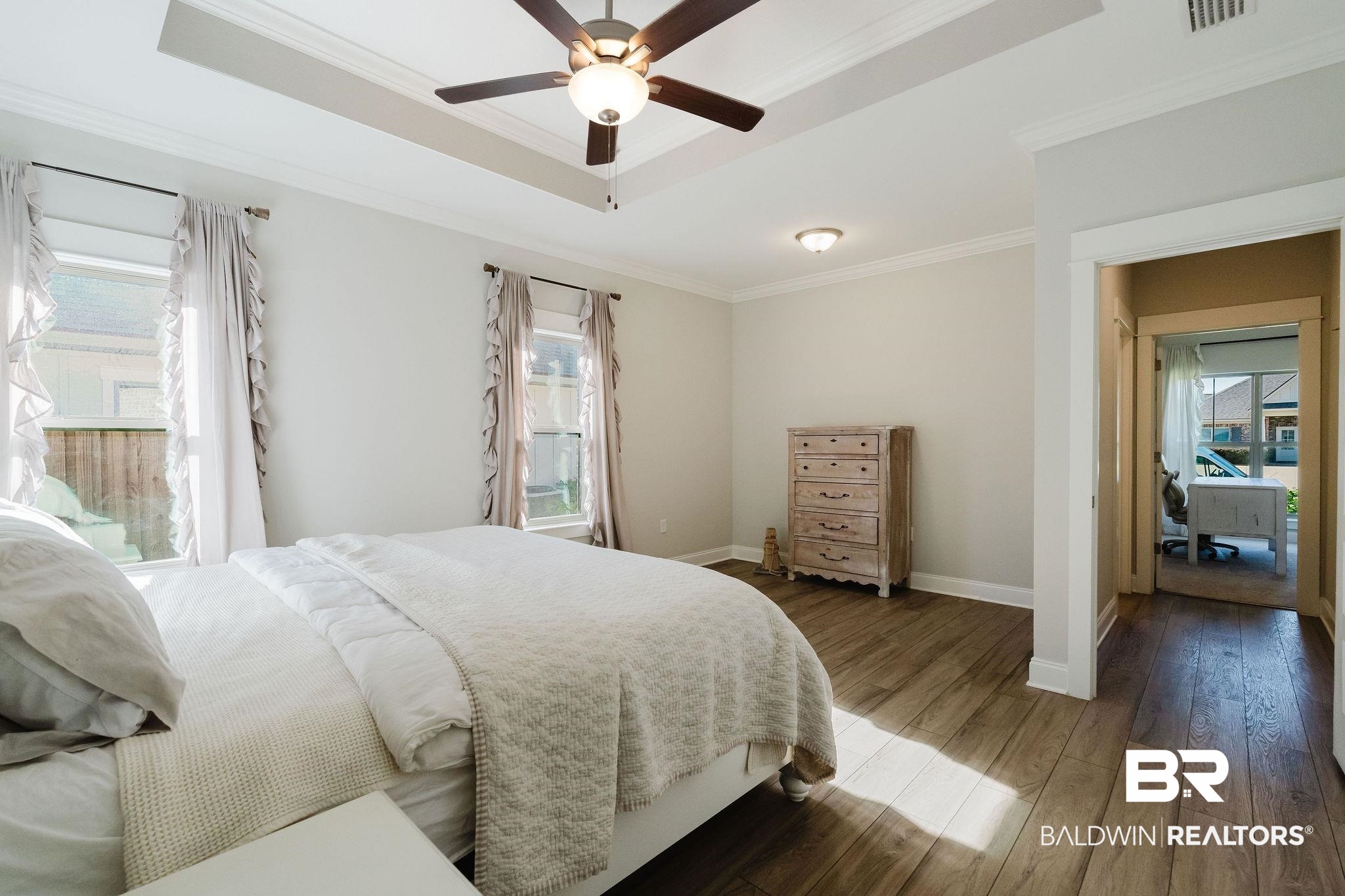 7872 Calverton Street Foley, AL 36535 - Photo 16 of 76 Recessed tray ceiling with ceiling fan and light fixture, wood-finish flooring, and recessed lighting