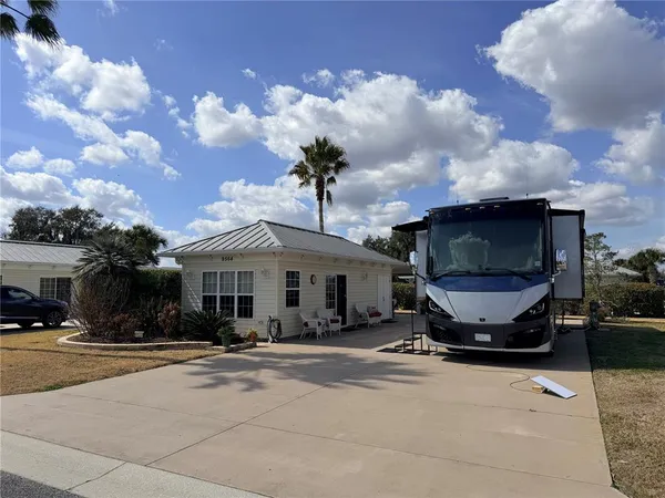 a view of a house with cars park