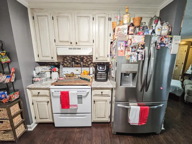 a kitchen with stainless steel appliances granite countertop a refrigerator and stove