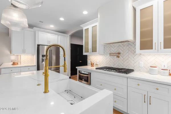 a kitchen with stainless steel appliances kitchen island granite countertop a table chairs sink and cabinets