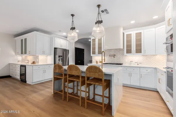 a kitchen with stainless steel appliances granite countertop a sink refrigerator and cabinets