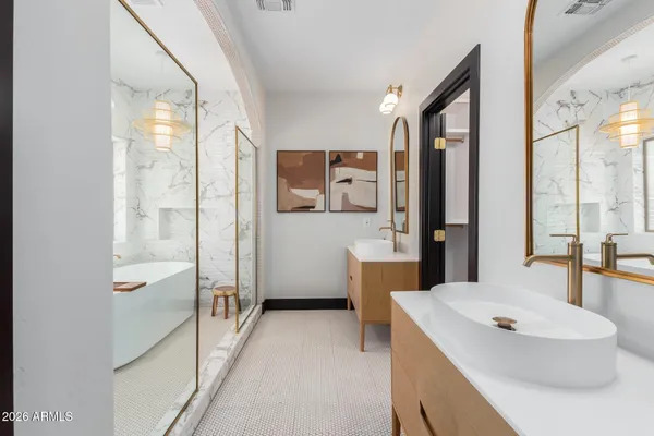 a en suite bathroom with a granite countertop double vanity and a mirror