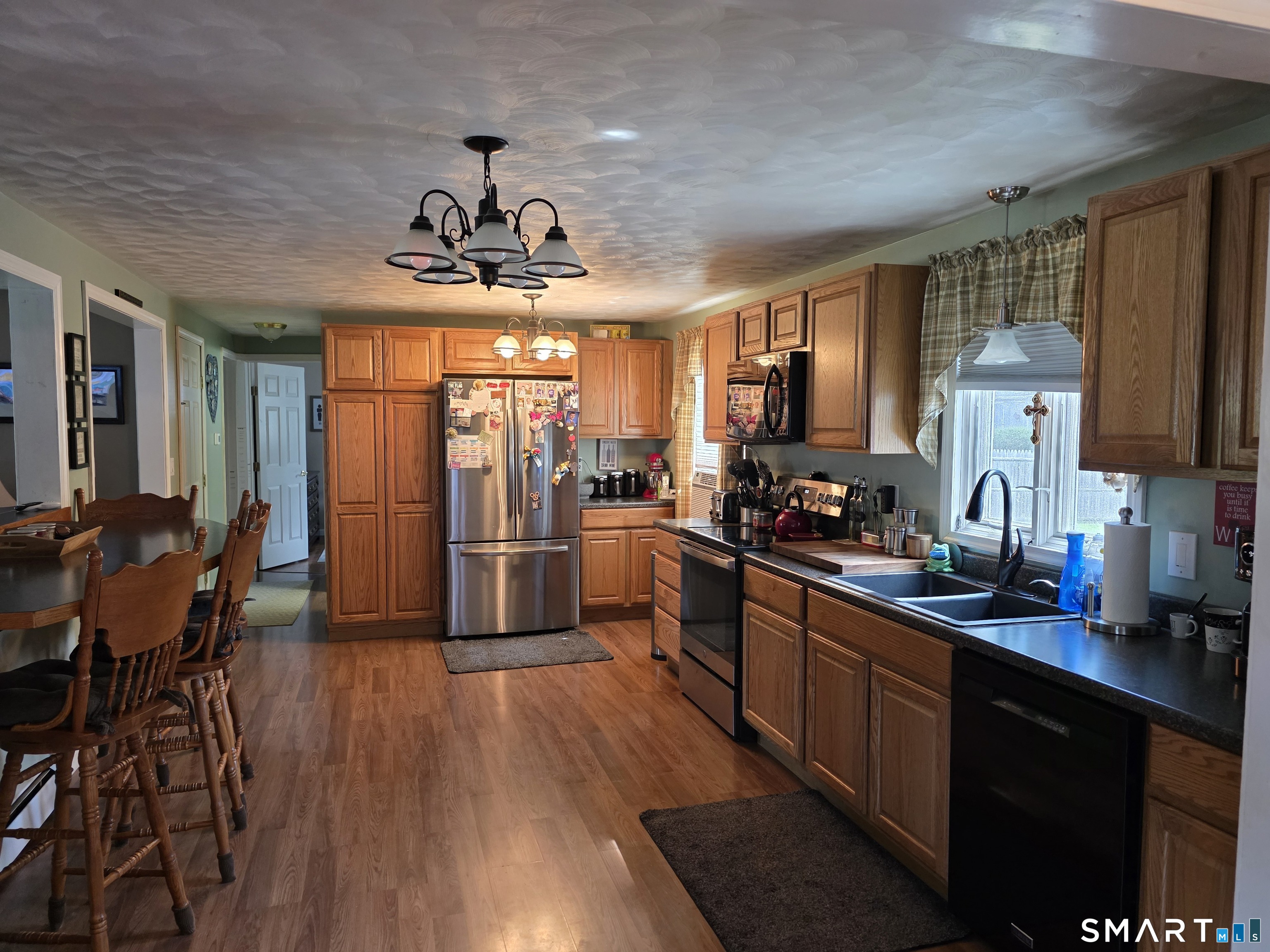 15 Van Buren Road Enfield, CT 06082 - Photo 22 of 40 a kitchen with stainless steel appliances granite countertop a refrigerator a sink dishwasher a stove and a dining table with wooden floor