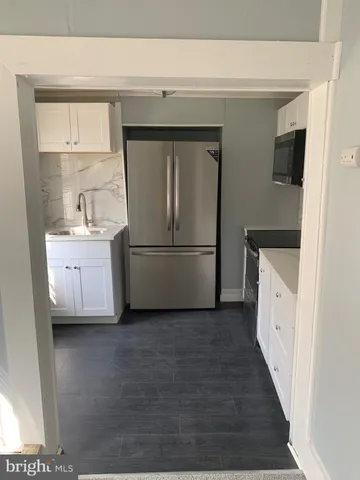 a kitchen with a refrigerator sink and cabinets
