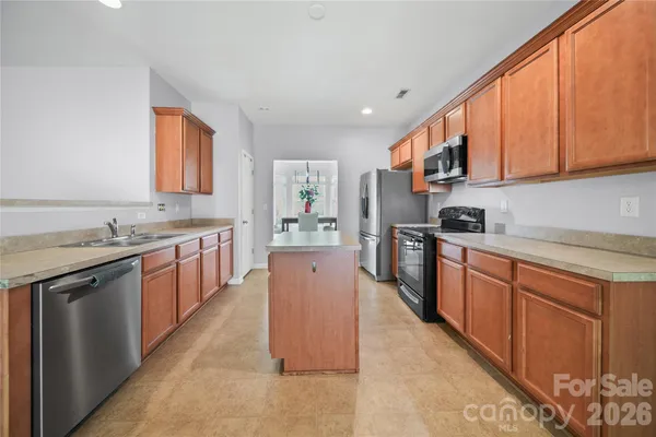 a large kitchen with stainless steel appliances granite countertop a stove a sink dishwasher and a refrigerator