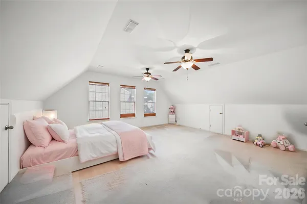 a spacious bedroom with a bed and a chandelier
