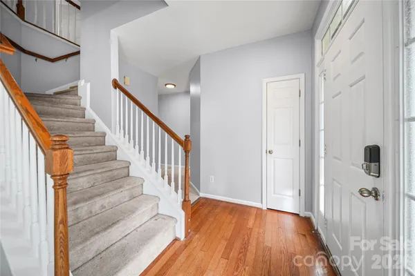 a view of a hallway with wooden floor and entryway