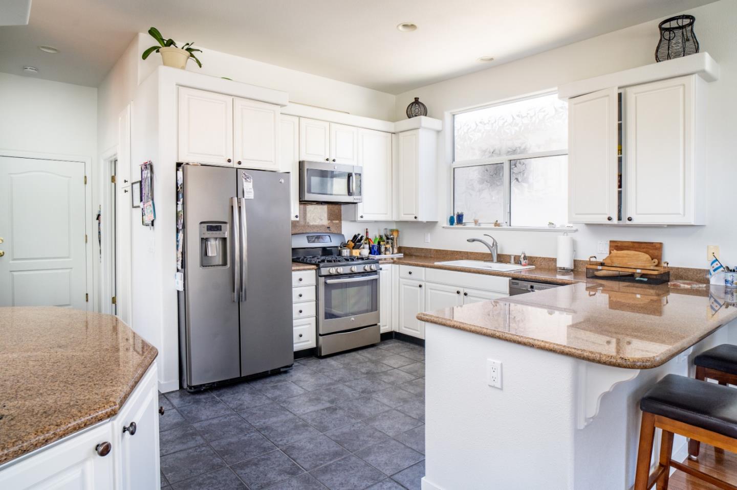928 Hellam Street Monterey, CA 93940 - Photo 5 of 25 a kitchen with a refrigerator a sink and cabinets