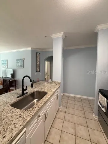 a kitchen with granite countertop a sink a stove and cabinets