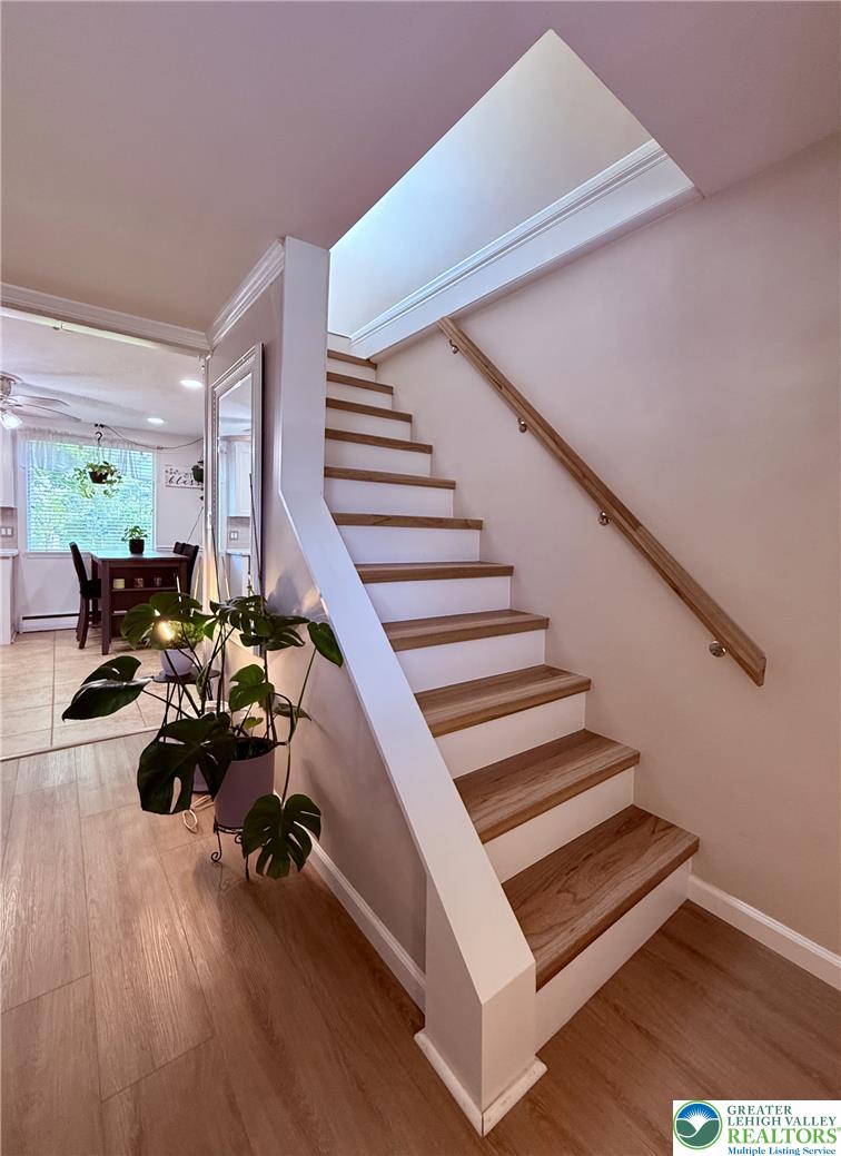 1275 Macada Road Bethlehem, PA 18017 - Photo 21 of 87 Natural wood stairs ascend, illuminated by a skylight, complementing the surrounding light wood flooring.