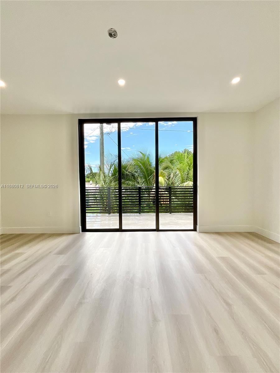 536 Northwest 48th Street Miami, FL 33127 - Photo 14 of 40 a view of an empty room with wooden floor and a window