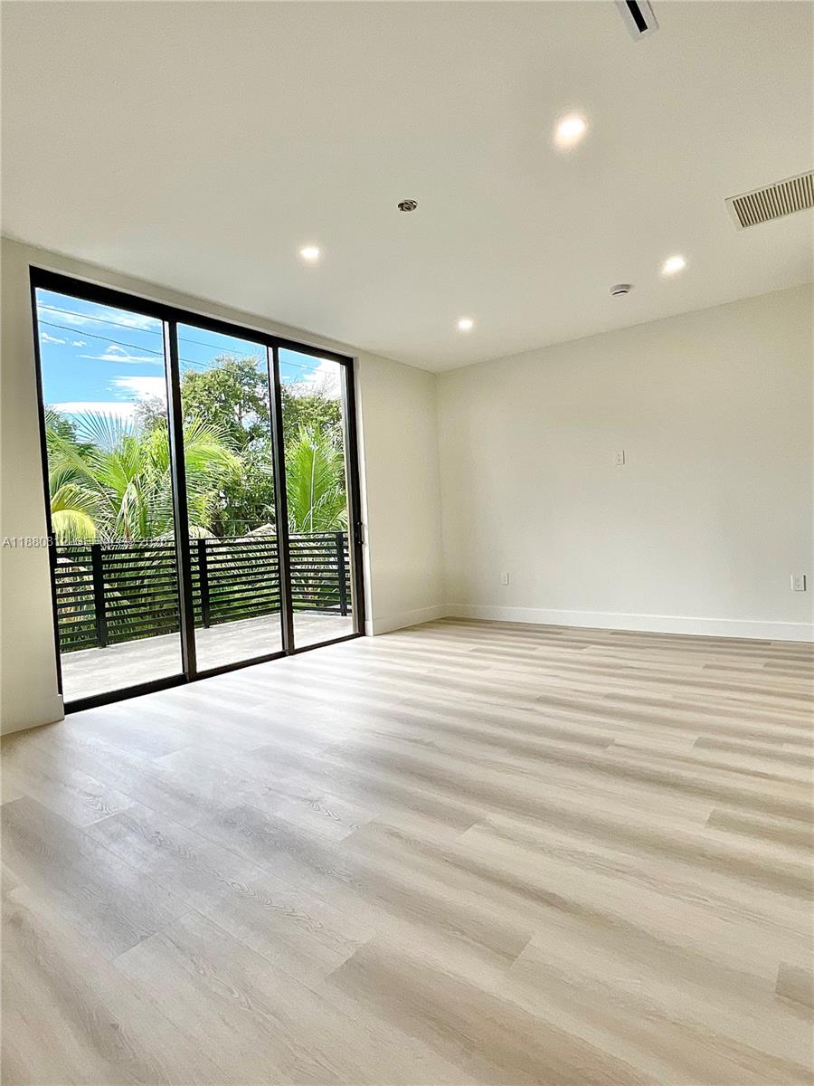 536 Northwest 48th Street Miami, FL 33127 - Photo 15 of 40 a view of an empty room with wooden floor and a window