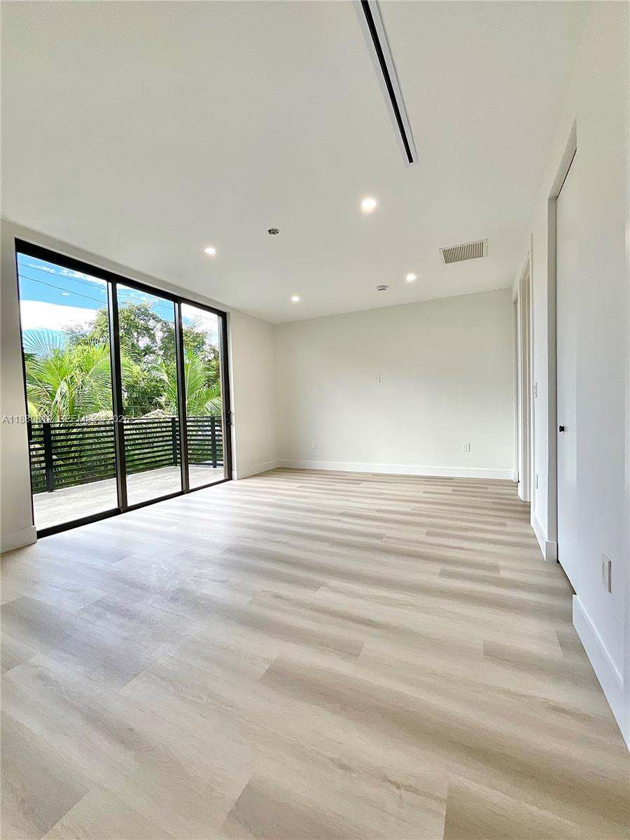 536 Northwest 48th Street Miami, FL 33127 - Photo 17 of 40 a view of an empty room with wooden floor and a window