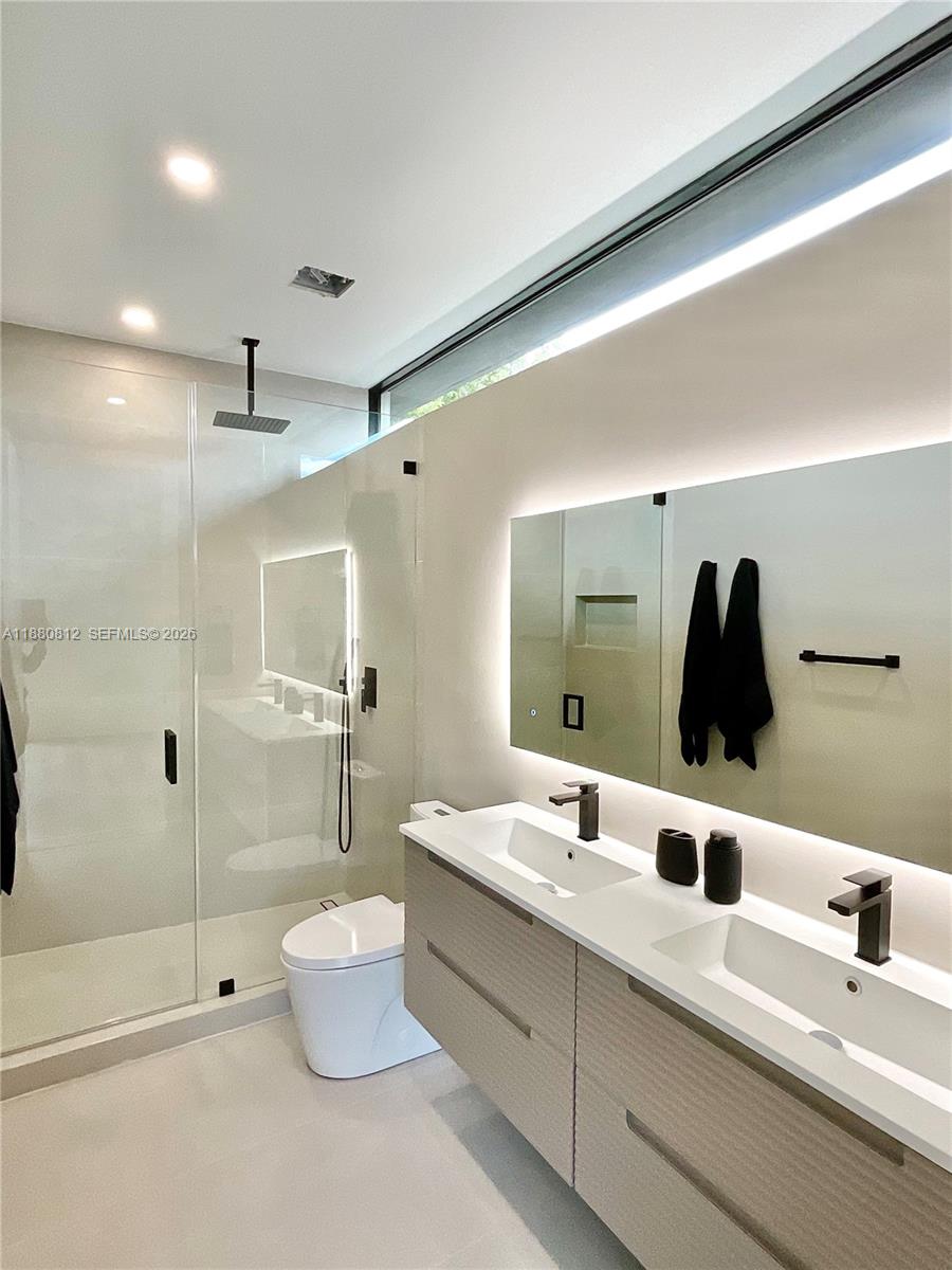 536 Northwest 48th Street Miami, FL 33127 - Photo 19 of 40 a bathroom with a double vanity sink toilet and shower