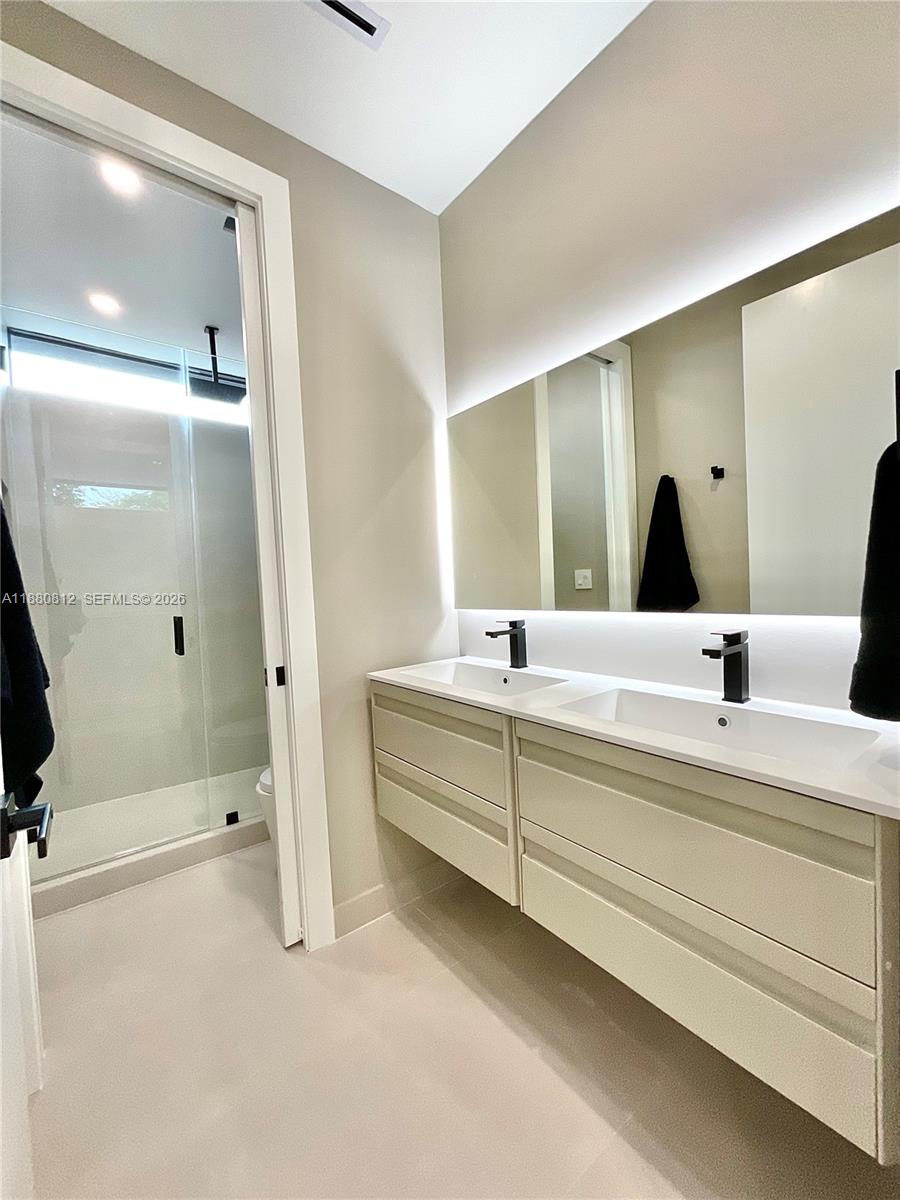 536 Northwest 48th Street Miami, FL 33127 - Photo 22 of 40 a bathroom with a double vanity sink and mirror