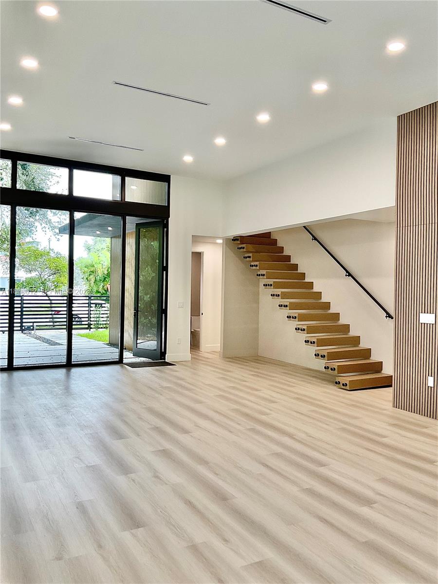 536 Northwest 48th Street Miami, FL 33127 - Photo 6 of 40 a view of an empty room with wooden floor and a window