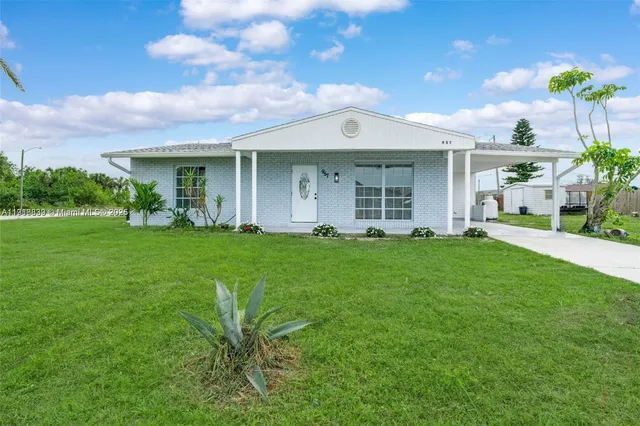 a front view of a house with a garden and yard