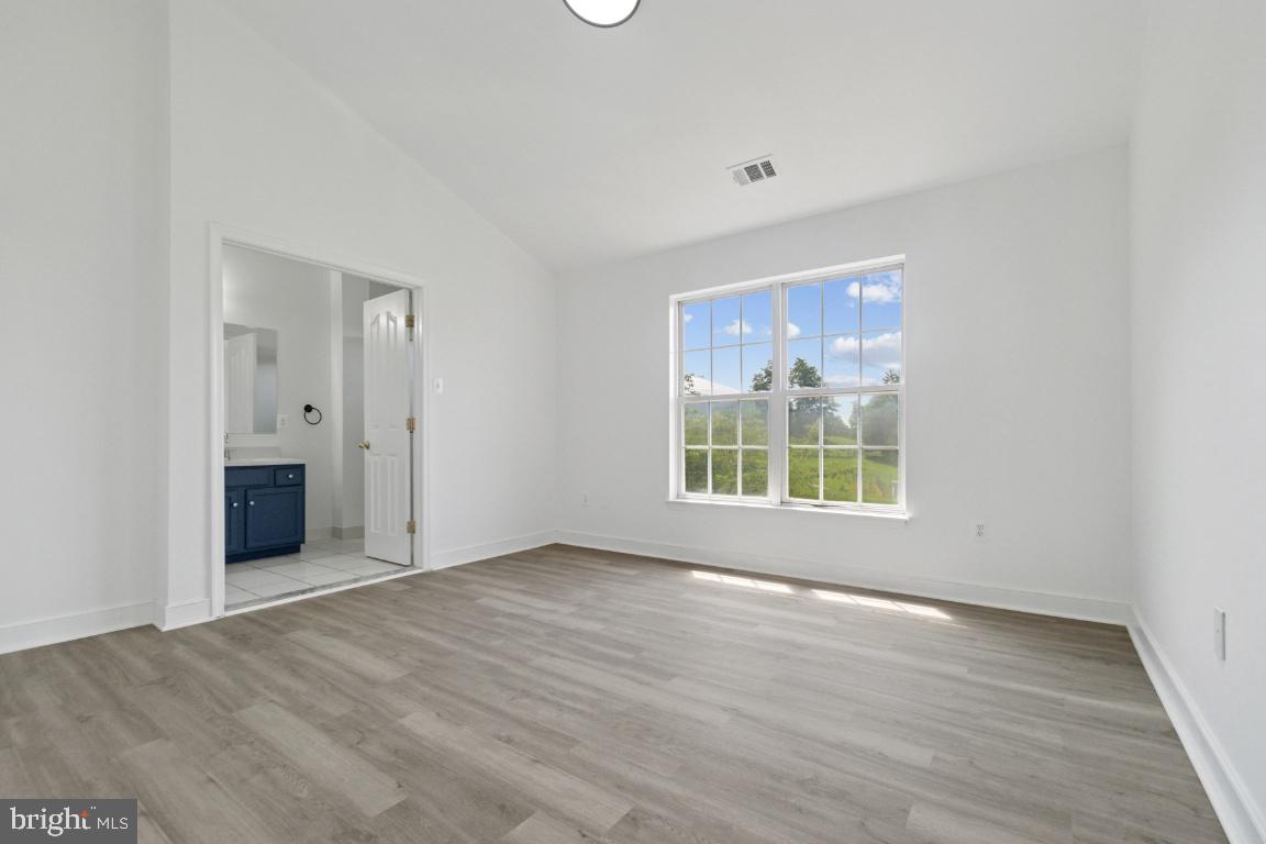 1109 Pomelo Court, Unit 1109 Baltimore, MD 21228 - Photo 15 of 40 an empty room with wooden floor and windows
