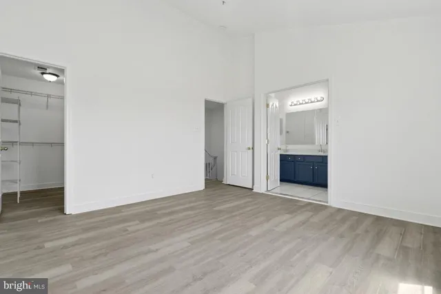an empty room with wooden floor and mirror