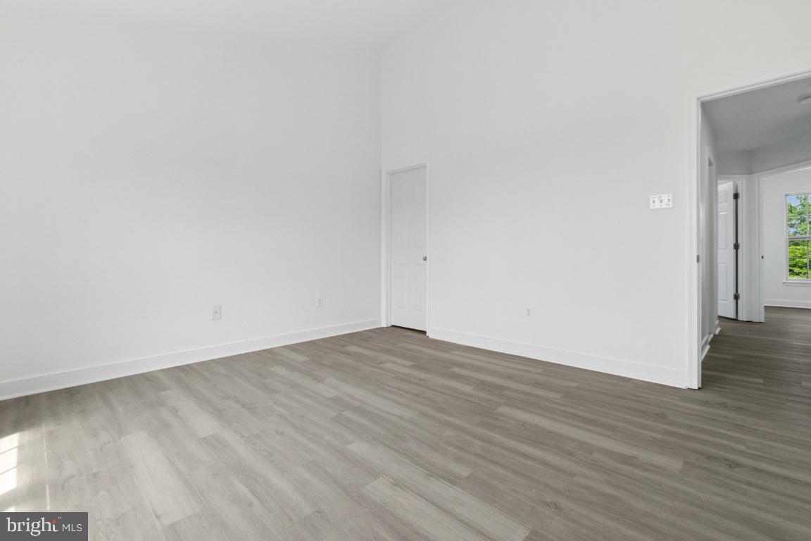 1109 Pomelo Court, Unit 1109 Baltimore, MD 21228 - Photo 19 of 40 a view of an empty room with wooden floor