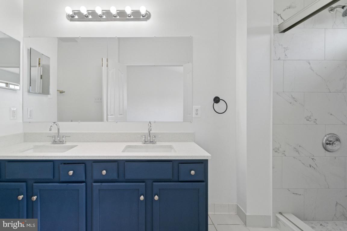 1109 Pomelo Court, Unit 1109 Baltimore, MD 21228 - Photo 20 of 40 a bathroom with a double vanity sink and mirror