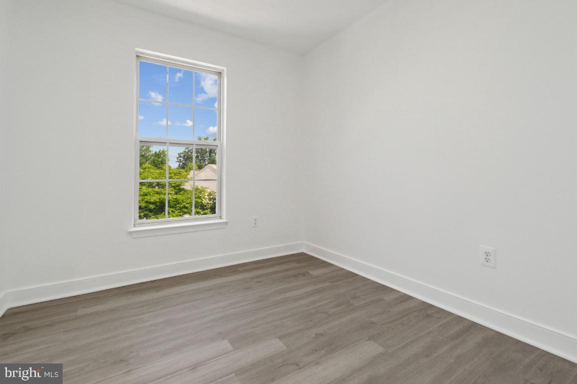 1109 Pomelo Court, Unit 1109 Baltimore, MD 21228 - Photo 25 of 40 an empty room with wooden floor and windows