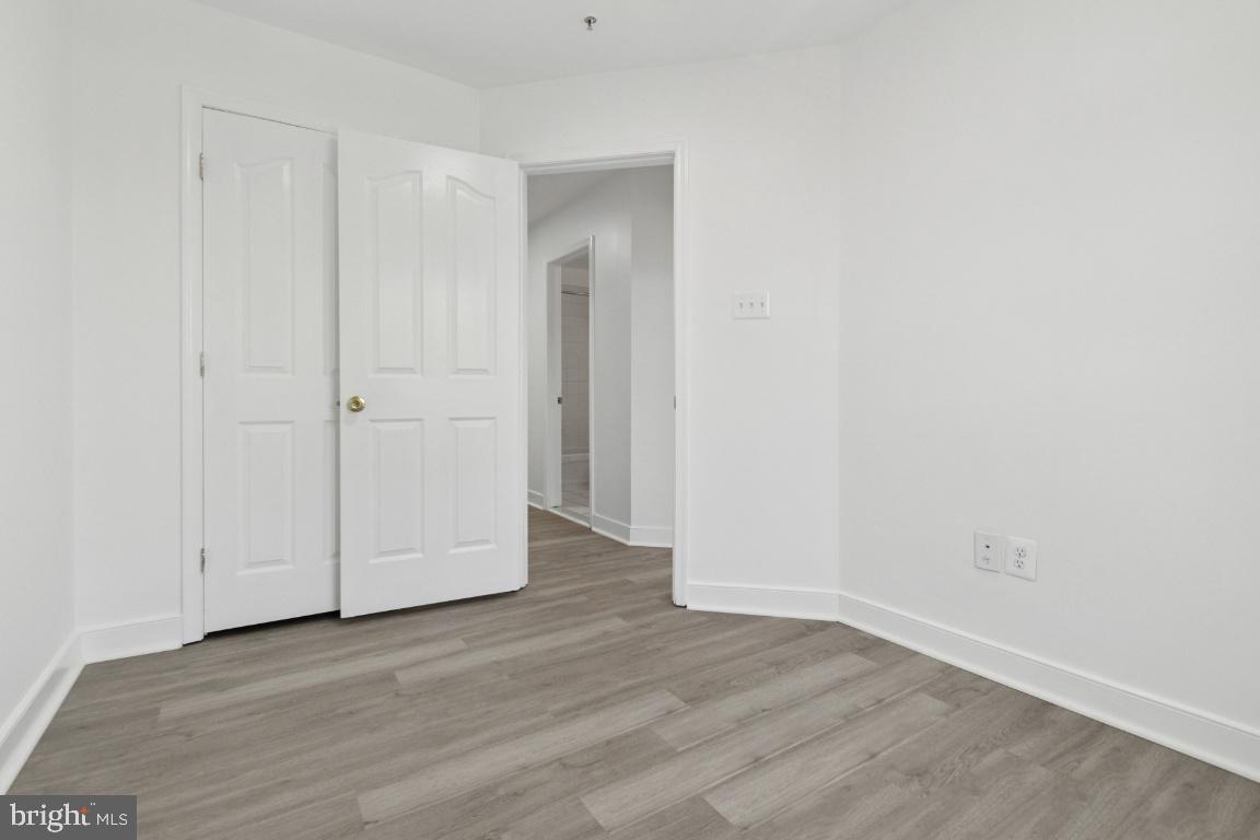 1109 Pomelo Court, Unit 1109 Baltimore, MD 21228 - Photo 26 of 40 a view of an empty room with wooden floor