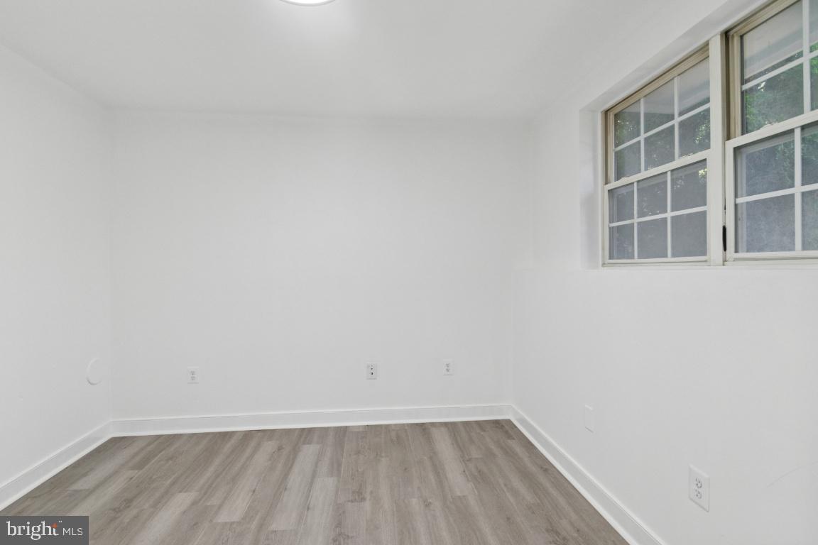1109 Pomelo Court, Unit 1109 Baltimore, MD 21228 - Photo 29 of 40 a view of an empty room with wooden floor and a window