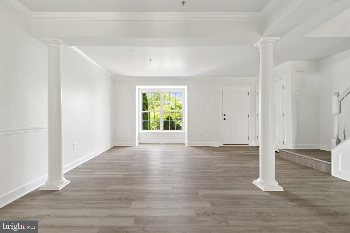 1109 Pomelo Court, Unit 1109 Baltimore, MD 21228 - Photo 3 of 40 a view of an empty room with wooden floor and a window