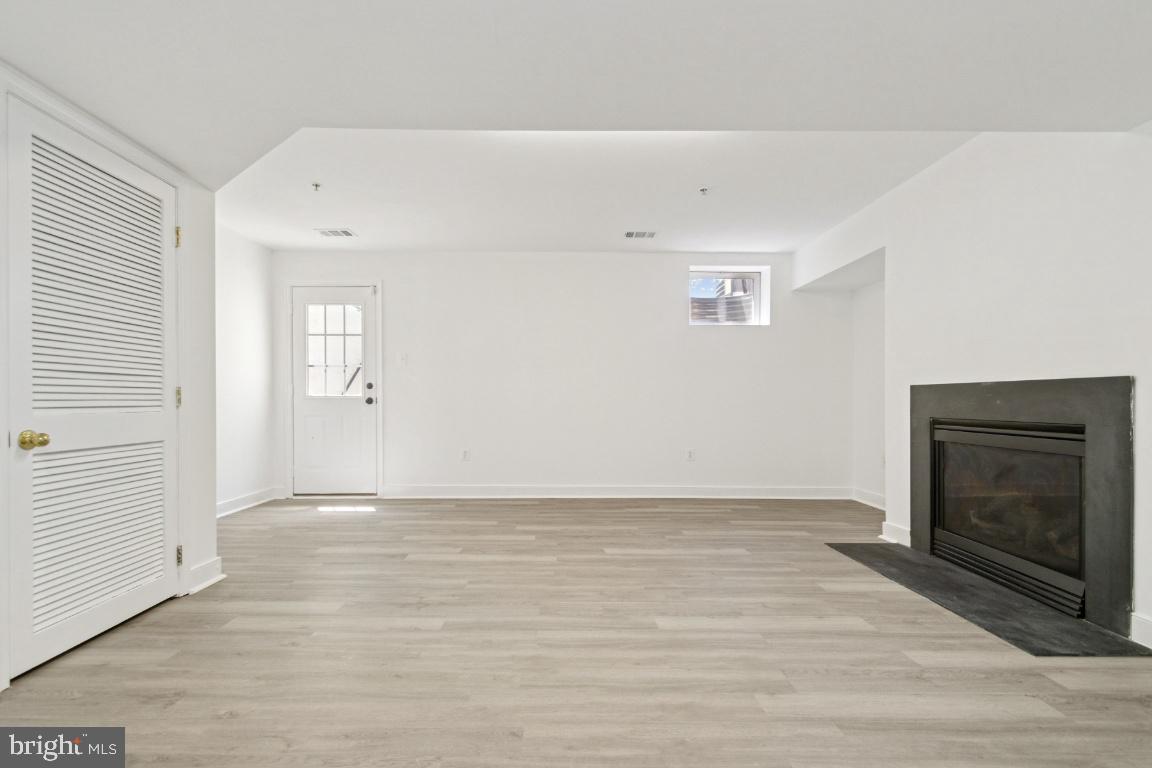 1109 Pomelo Court, Unit 1109 Baltimore, MD 21228 - Photo 33 of 40 a view of an empty room with wooden floor and a window
