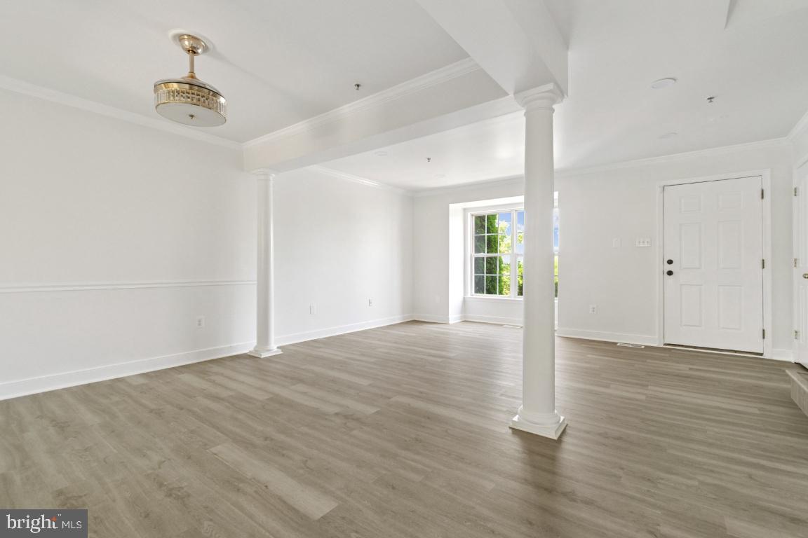 1109 Pomelo Court, Unit 1109 Baltimore, MD 21228 - Photo 6 of 40 a view of an empty room with wooden floor and a window