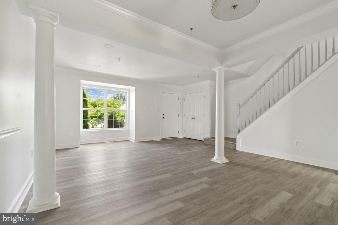 1109 Pomelo Court, Unit 1109 Baltimore, MD 21228 - Photo 7 of 40 a view of an empty room with wooden floor and a window